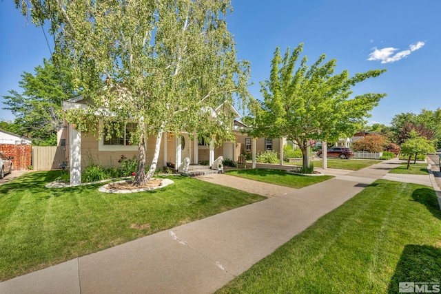 view of property hidden behind natural elements featuring a front yard