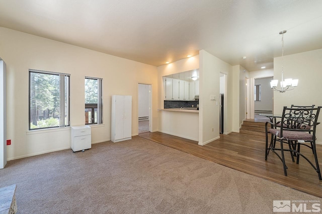 living room featuring a notable chandelier, wood-type flooring, and a baseboard radiator