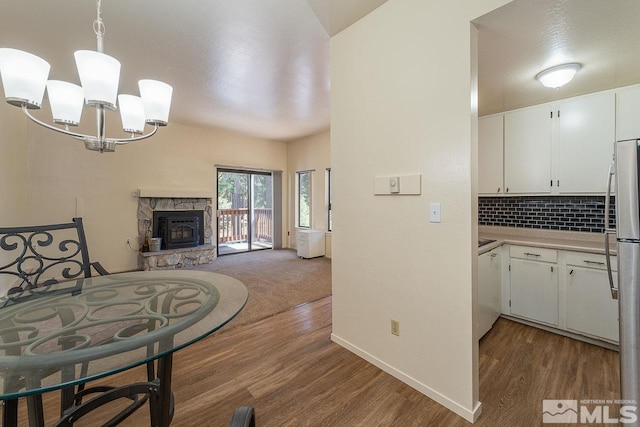 kitchen featuring white cabinetry, dark hardwood / wood-style flooring, a notable chandelier, backsplash, and pendant lighting