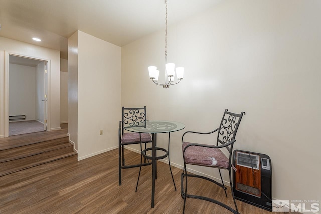 dining space featuring hardwood / wood-style flooring, an inviting chandelier, a baseboard radiator, and heating unit