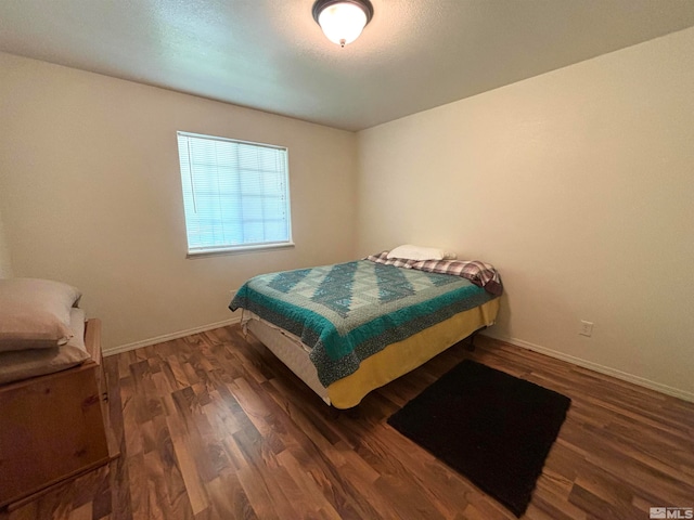 bedroom with dark wood-type flooring