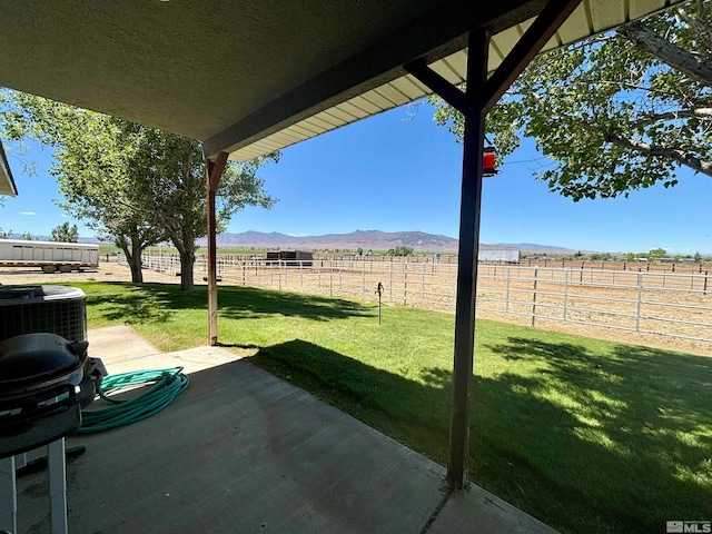 view of terrace featuring central AC unit, a mountain view, and a rural view