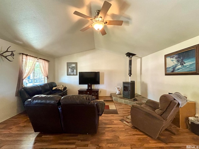 living room featuring lofted ceiling, wood-type flooring, ceiling fan, and a wood stove