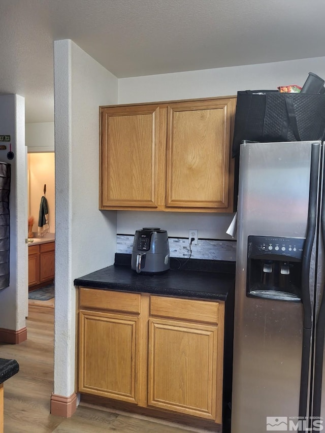 kitchen with stainless steel fridge and light hardwood / wood-style floors