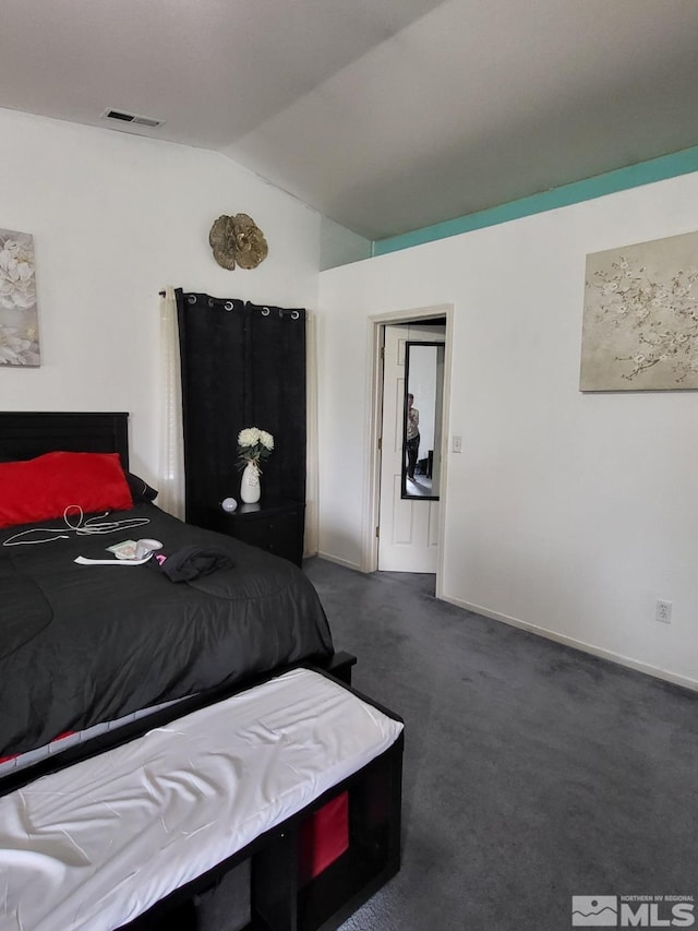 bedroom with lofted ceiling and dark carpet