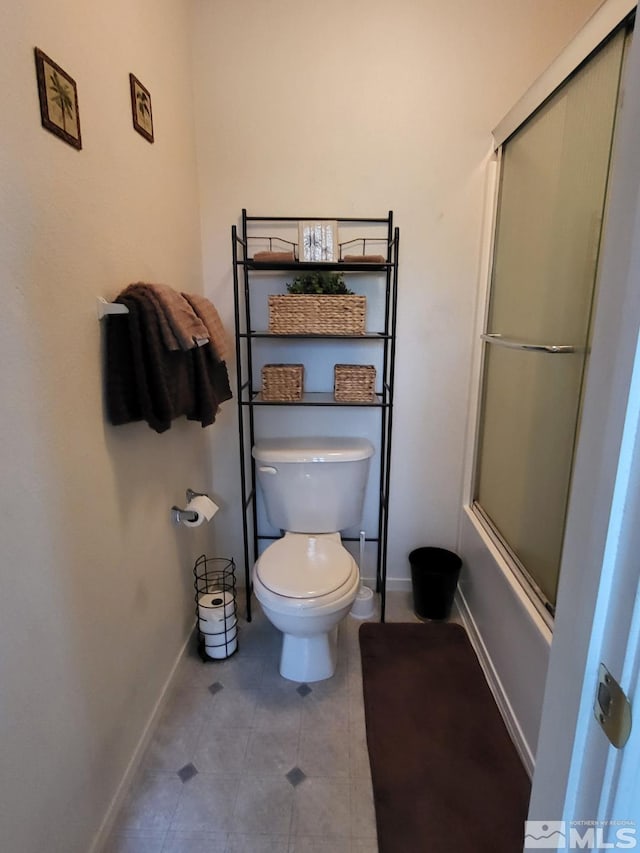 bathroom featuring combined bath / shower with glass door and toilet