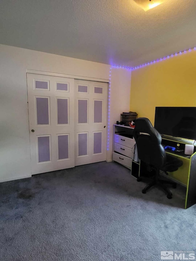 office area featuring dark carpet and a textured ceiling