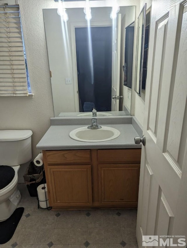 bathroom featuring vanity, tile patterned floors, and toilet