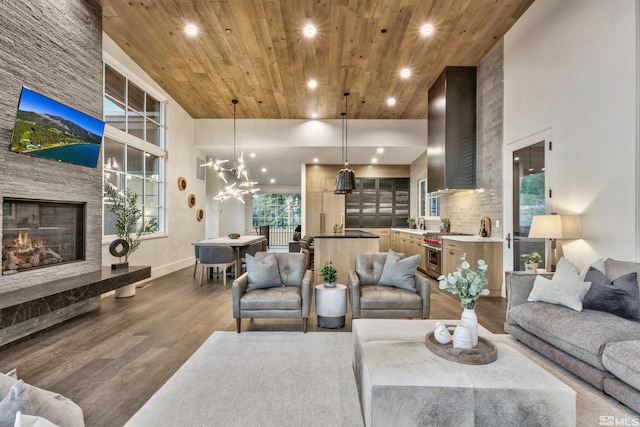 living room with dark hardwood / wood-style floors, a stone fireplace, wood ceiling, and a high ceiling