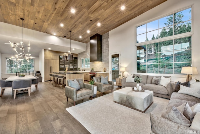 living room with hardwood / wood-style floors, wooden ceiling, a high ceiling, and a chandelier