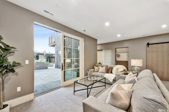 carpeted living room with a barn door