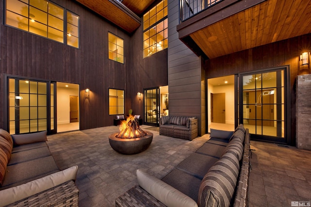 view of patio featuring a balcony and an outdoor living space with a fire pit