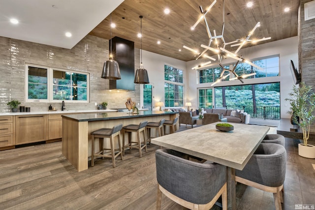 dining area featuring sink, a towering ceiling, and hardwood / wood-style flooring