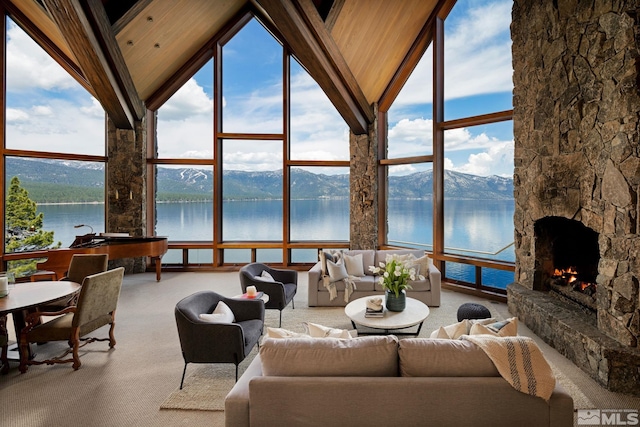 living room with a fireplace, a water and mountain view, high vaulted ceiling, and carpet flooring