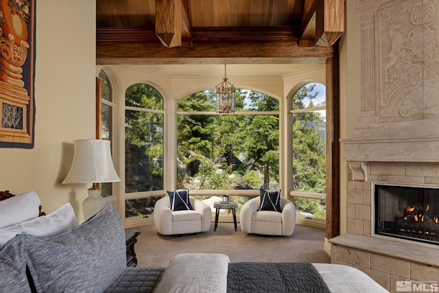 interior space with a healthy amount of sunlight, a fireplace, and beamed ceiling