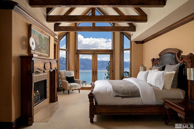 carpeted bedroom featuring a water view, a high end fireplace, access to exterior, and beamed ceiling