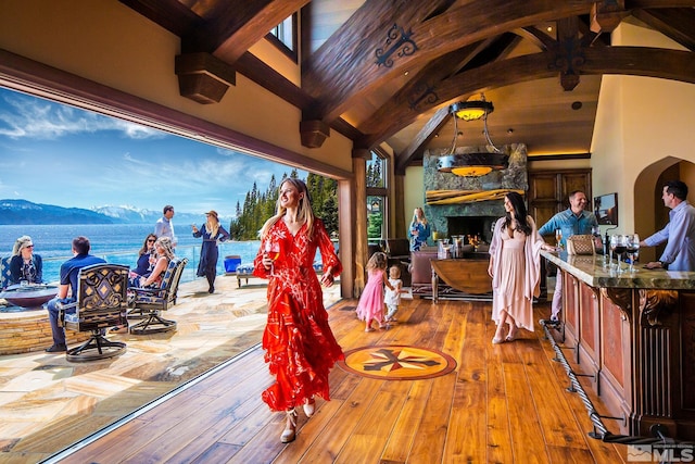 interior space with a water and mountain view, an outdoor bar, and an outdoor stone fireplace