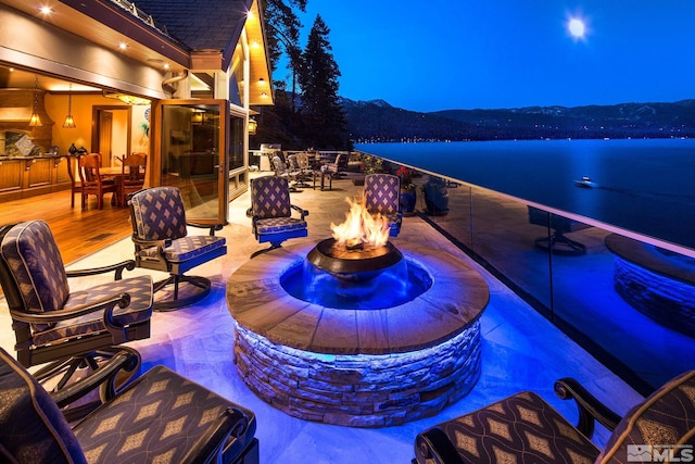 view of patio / terrace featuring a water view and a fire pit