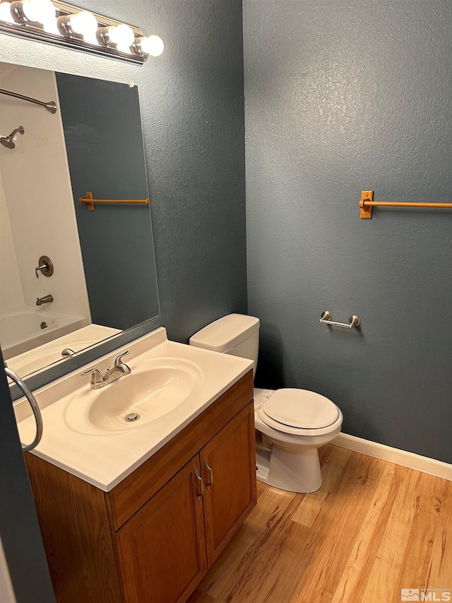 bathroom featuring toilet, hardwood / wood-style flooring, and vanity