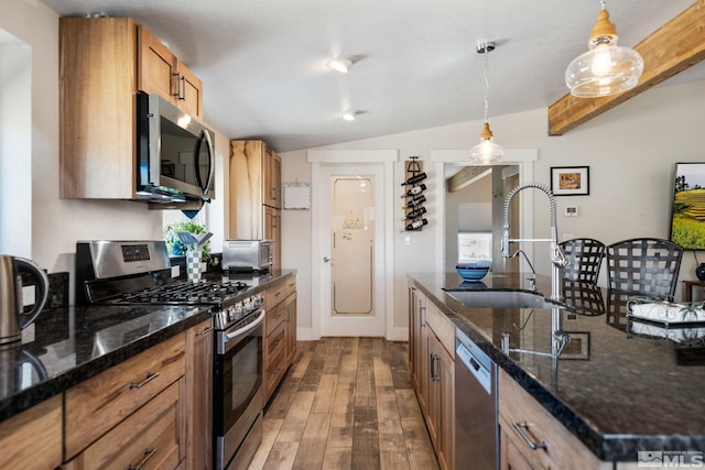 kitchen featuring sink, dark wood-type flooring, pendant lighting, lofted ceiling, and appliances with stainless steel finishes