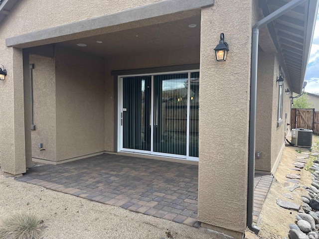 doorway to property featuring cooling unit and a patio area