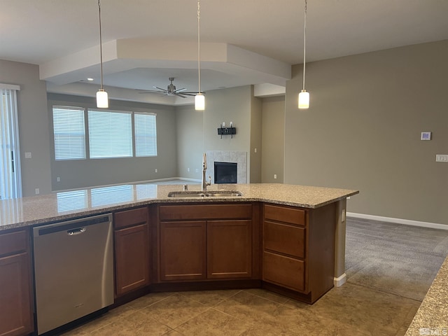 kitchen with sink, hanging light fixtures, stainless steel dishwasher, ceiling fan, and light stone counters