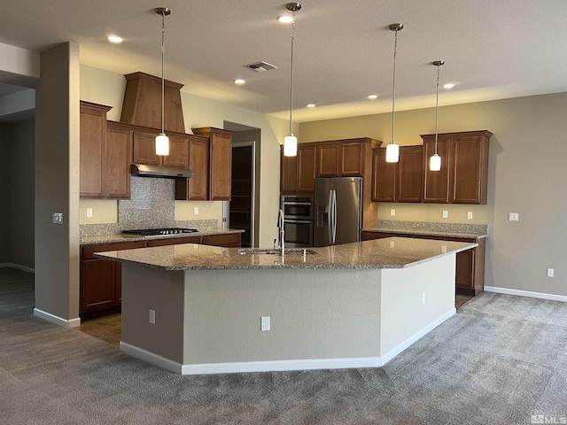 kitchen featuring stainless steel appliances, backsplash, pendant lighting, a center island with sink, and dark carpet