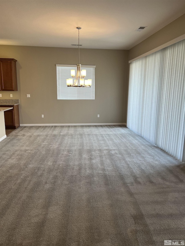 unfurnished dining area with carpet floors and a chandelier