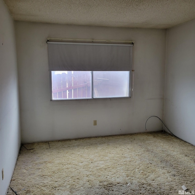 unfurnished room with a textured ceiling