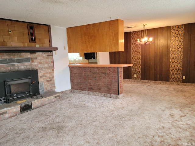 interior space featuring carpet floors, a textured ceiling, and wooden walls