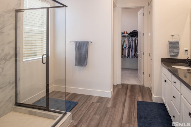 bathroom with hardwood / wood-style flooring, vanity, and a shower with door