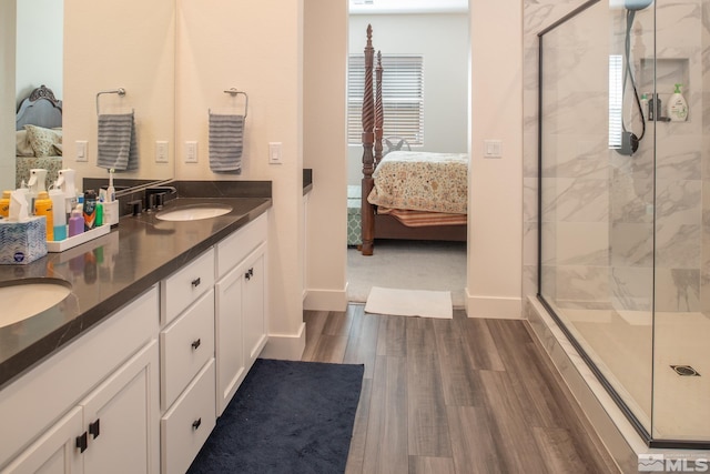 bathroom featuring hardwood / wood-style floors, vanity, and a shower with door