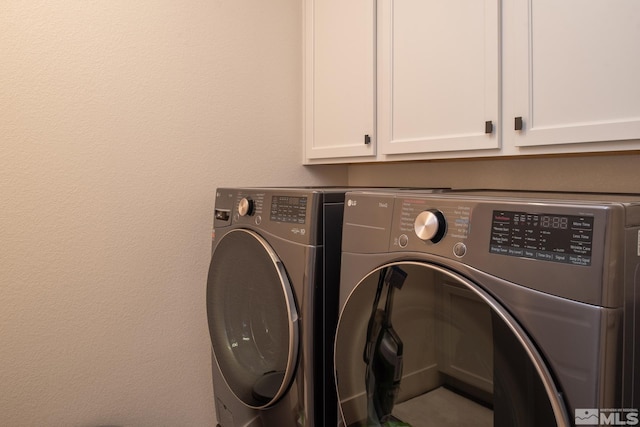 laundry area featuring washer and dryer and cabinets