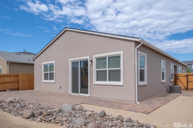 rear view of property featuring central AC unit and a patio