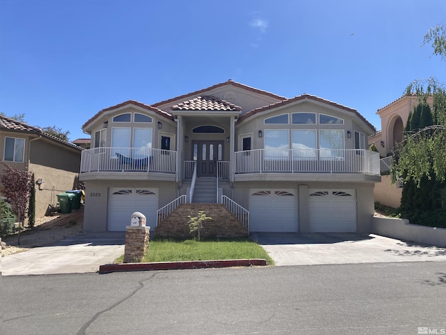 view of front of house featuring stairway, a garage, concrete driveway, and a tiled roof