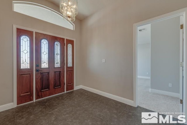 tiled entrance foyer featuring a chandelier