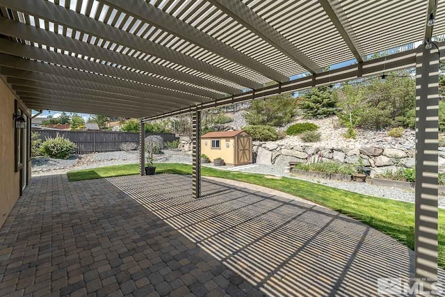 view of patio with a pergola and a shed