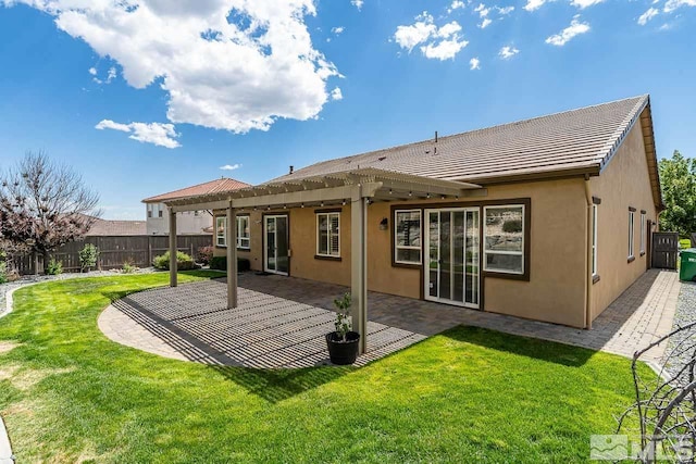 rear view of house featuring a patio area and a lawn