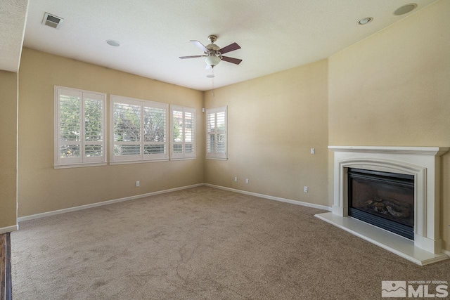 unfurnished living room with carpet and ceiling fan