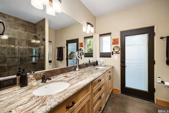 kitchen with lofted ceiling, a kitchen island with sink, light stone countertops, appliances with stainless steel finishes, and a kitchen bar