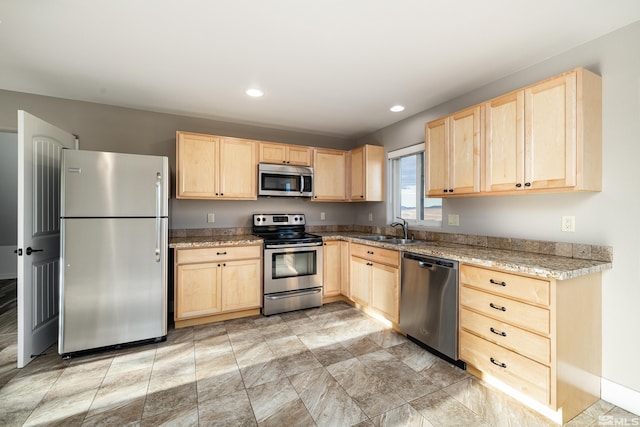 kitchen with ceiling fan, light brown cabinetry, stainless steel appliances, and light stone counters