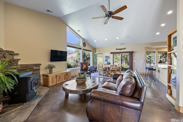 living room featuring a wood stove, ceiling fan, high vaulted ceiling, and dark colored carpet