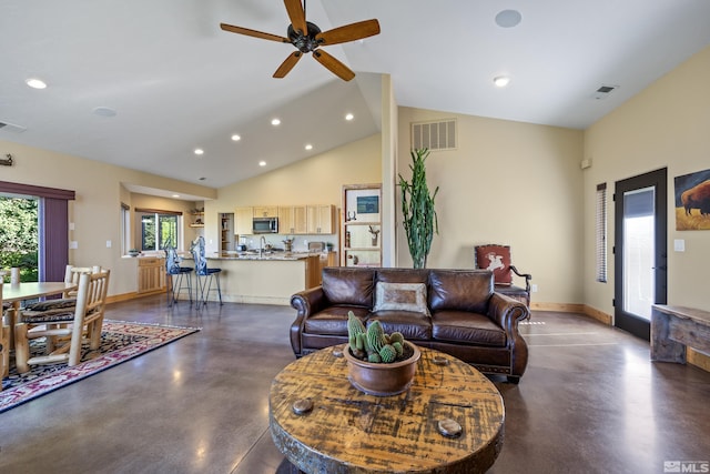 living room with ceiling fan, built in features, a wood stove, and vaulted ceiling