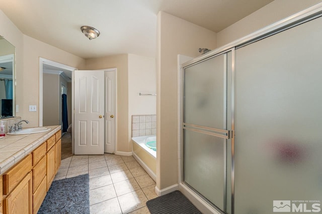 bathroom with tile patterned flooring, vanity, and shower with separate bathtub