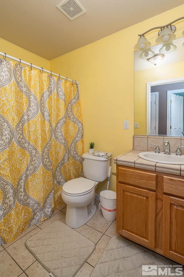 bathroom featuring tile patterned floors, vanity, and toilet