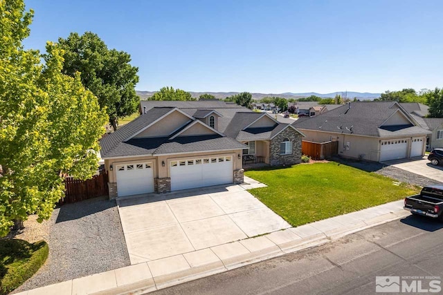 ranch-style house with a mountain view, a front yard, and a garage