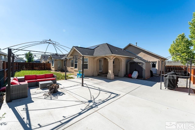 view of front of home featuring a patio area and an outdoor living space with a fire pit