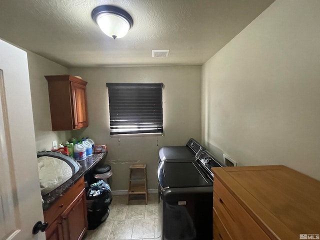 laundry area with independent washer and dryer, sink, cabinets, and light tile floors