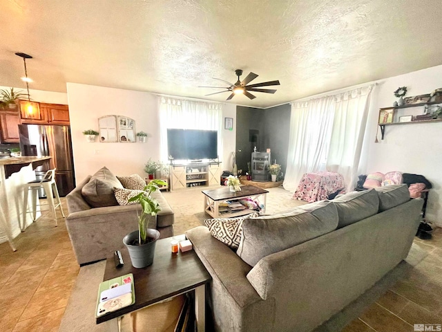 tiled living room featuring ceiling fan and a textured ceiling