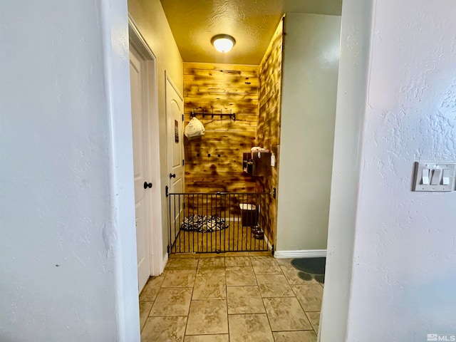 hall featuring wood walls and light tile flooring